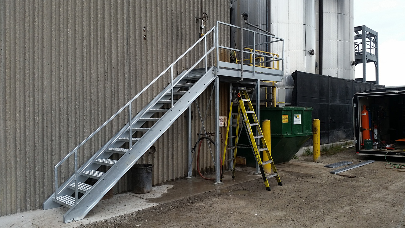 metal stairs leading to steel room with yellow ladder underneath 2